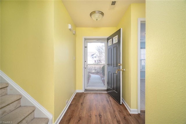 doorway to outside with stairway, baseboards, visible vents, and dark wood finished floors