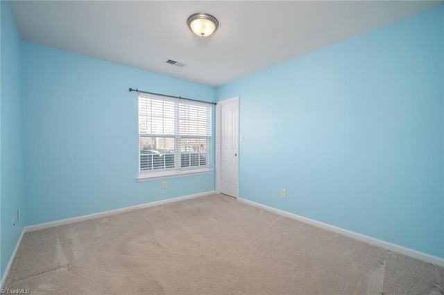 spare room featuring visible vents, carpet, and baseboards