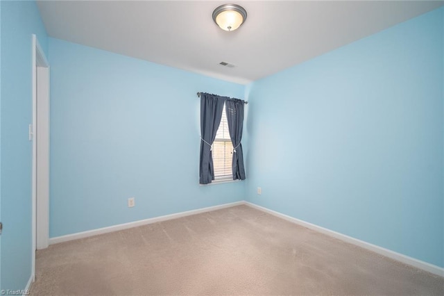 carpeted empty room featuring baseboards and visible vents