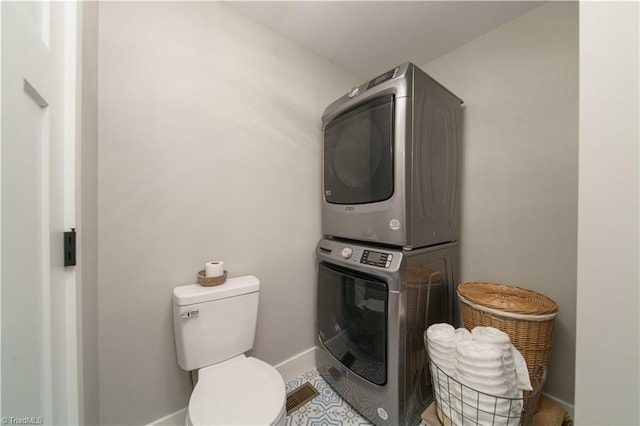 laundry area featuring laundry area, stacked washer and clothes dryer, and baseboards