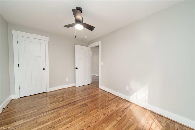 unfurnished bedroom featuring baseboards, light wood finished floors, and ceiling fan