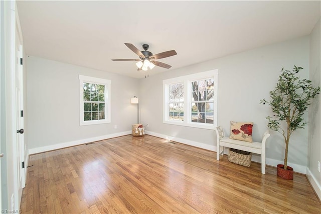 interior space with baseboards, light wood-style floors, and ceiling fan