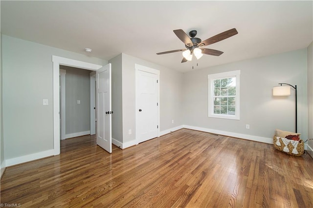 unfurnished bedroom with wood finished floors, baseboards, and ceiling fan