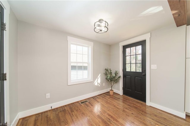 foyer with visible vents, baseboards, and wood finished floors