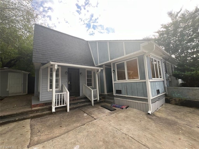 view of front of house featuring a storage shed and a patio area