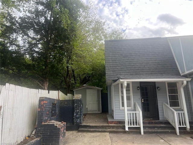 exterior space with a storage shed and a porch