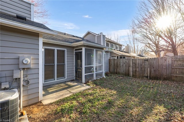 back of house with a sunroom, fence, a chimney, and central air condition unit