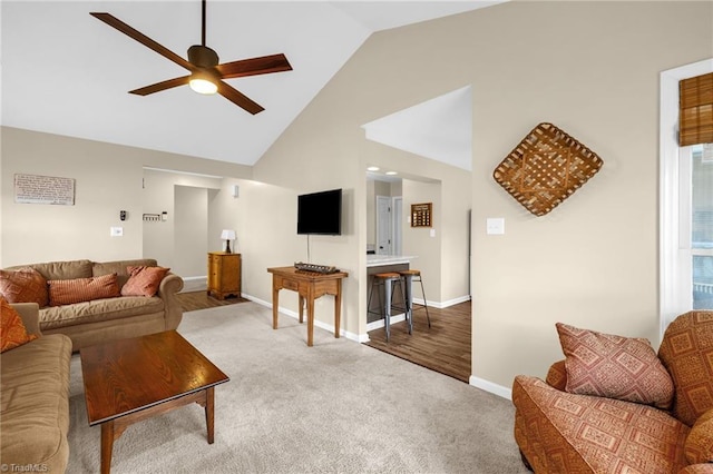 living room featuring high vaulted ceiling, carpet flooring, baseboards, and a ceiling fan