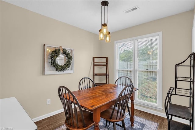 dining room featuring baseboards, visible vents, and dark wood-style flooring