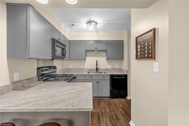 kitchen with visible vents, light countertops, gray cabinetry, black appliances, and a sink