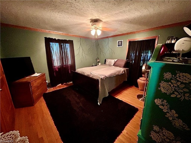 bedroom featuring crown molding, a ceiling fan, a textured ceiling, and wood finished floors