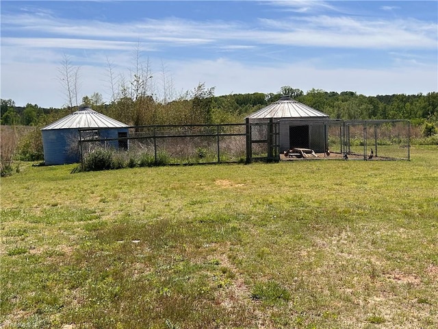 view of yard with fence and an outbuilding