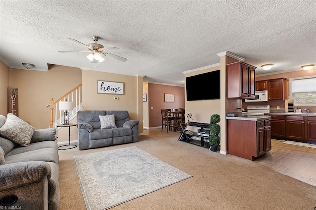 living room featuring stairway, ceiling fan, a textured ceiling, crown molding, and light colored carpet