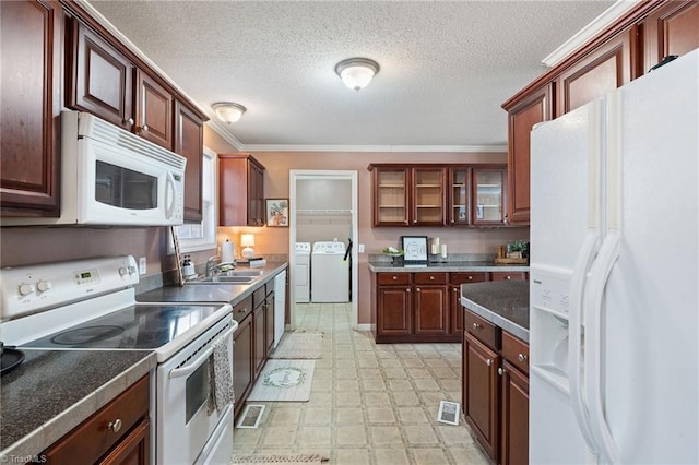 kitchen featuring washing machine and clothes dryer, visible vents, glass insert cabinets, light floors, and white appliances