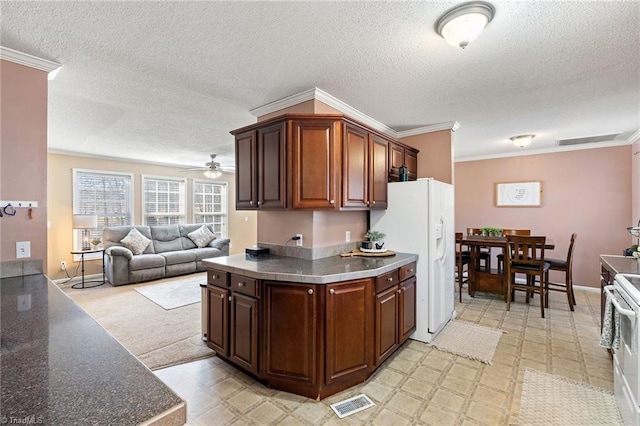 kitchen with white appliances, a ceiling fan, ornamental molding, dark countertops, and open floor plan