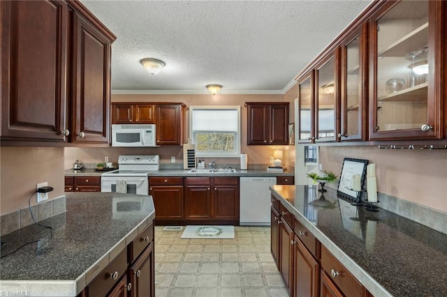 kitchen featuring white appliances, ornamental molding, light floors, and a sink