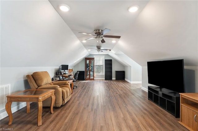 interior space featuring a ceiling fan, wood finished floors, visible vents, baseboards, and vaulted ceiling