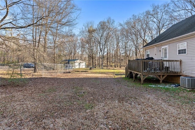 view of yard with cooling unit, a wooden deck, and fence