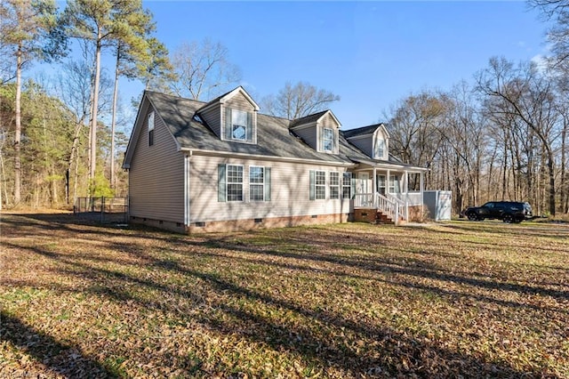 view of side of property featuring crawl space, a lawn, and covered porch