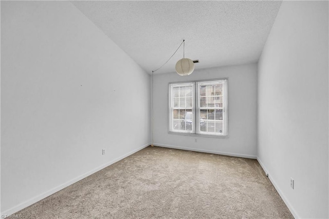 spare room with carpet floors, a textured ceiling, and baseboards