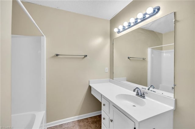 full bathroom featuring bathtub / shower combination, vanity, baseboards, and a textured ceiling