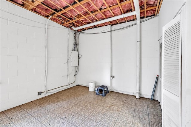 unfinished basement featuring light floors and electric panel