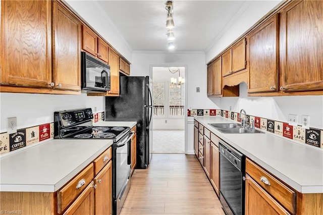 kitchen with a chandelier, black appliances, a sink, and light countertops