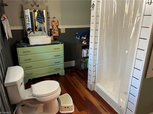 bathroom with curtained shower, toilet, wood-type flooring, and sink