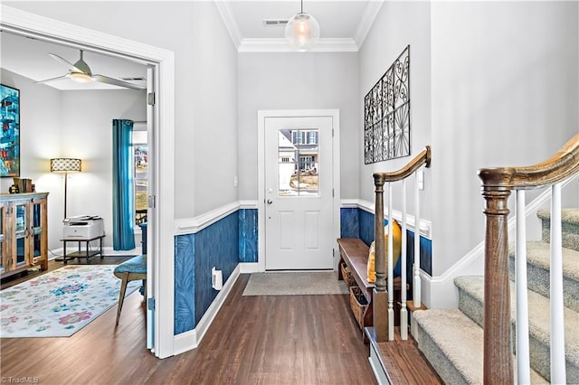 foyer entrance with dark wood-style flooring, a ceiling fan, visible vents, stairs, and crown molding