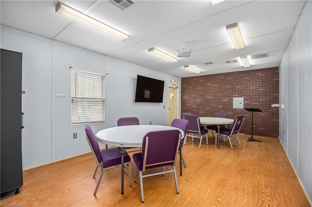 1255 Mountain View Rd, King, NC 27021 - dining area with visible vents, brick wall, and light wood finished floors