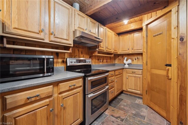 kitchen featuring appliances with stainless steel finishes, dark tile patterned floors, beam ceiling, and wood ceiling