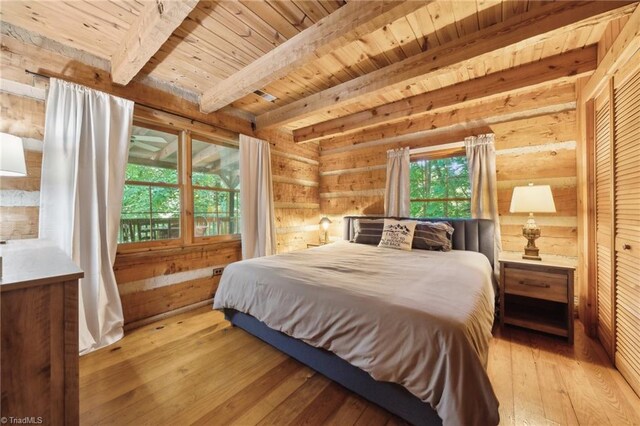 bedroom with log walls, wooden ceiling, light hardwood / wood-style floors, and beam ceiling