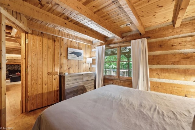 bedroom with wooden walls, beamed ceiling, hardwood / wood-style floors, and wooden ceiling