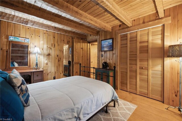 bedroom with wood walls, wood ceiling, beam ceiling, and light hardwood / wood-style floors