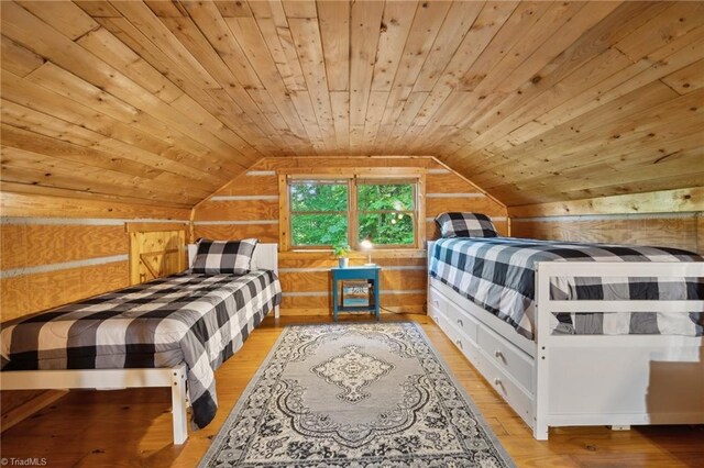 bedroom with wooden walls, lofted ceiling, light hardwood / wood-style flooring, and wood ceiling