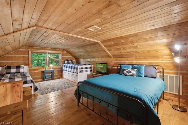 bedroom featuring wood walls, light hardwood / wood-style flooring, vaulted ceiling, and wood ceiling