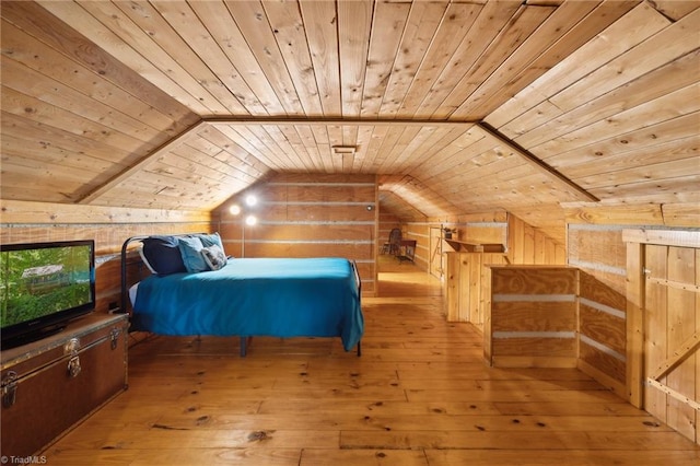 bedroom with light wood-type flooring, wood walls, and wooden ceiling