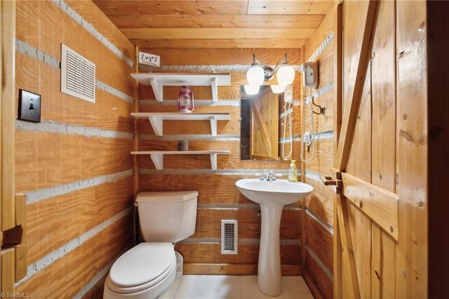 bathroom with wood ceiling, tile patterned floors, wooden walls, and toilet