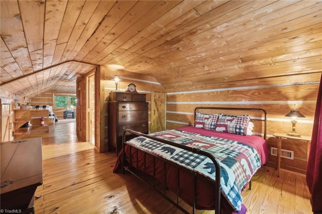 bedroom with wooden walls, wooden ceiling, light hardwood / wood-style flooring, and lofted ceiling