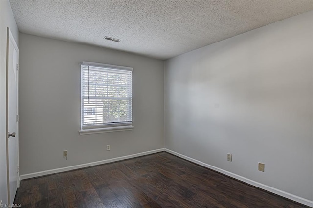 spare room with dark hardwood / wood-style flooring and a textured ceiling