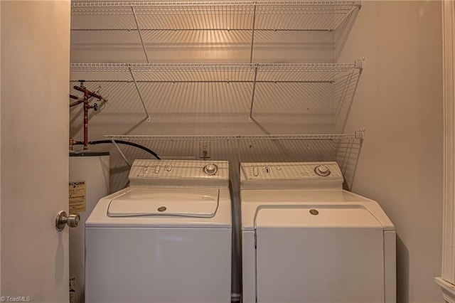 laundry room with gas water heater and washing machine and clothes dryer