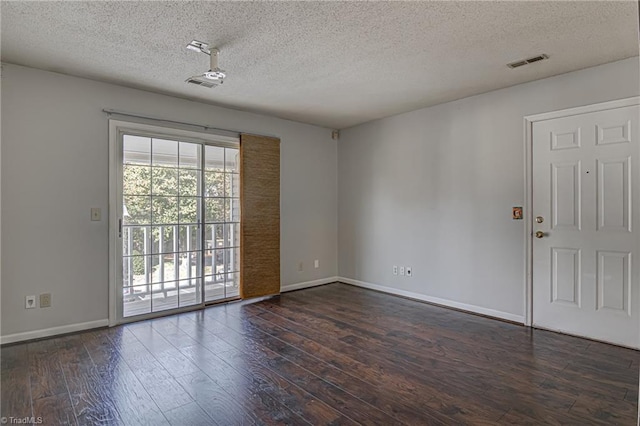 unfurnished room with dark wood-type flooring and a textured ceiling