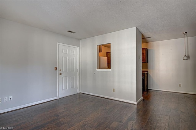 unfurnished room with dark hardwood / wood-style floors and a textured ceiling