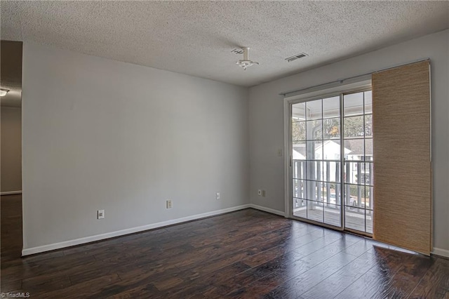 empty room featuring dark hardwood / wood-style flooring and a textured ceiling