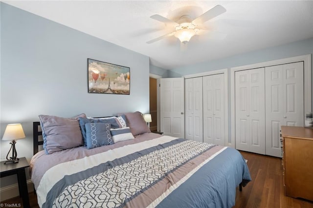 bedroom featuring ceiling fan, multiple closets, and wood finished floors