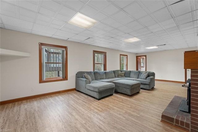 living room featuring a wealth of natural light, baseboards, and wood finished floors