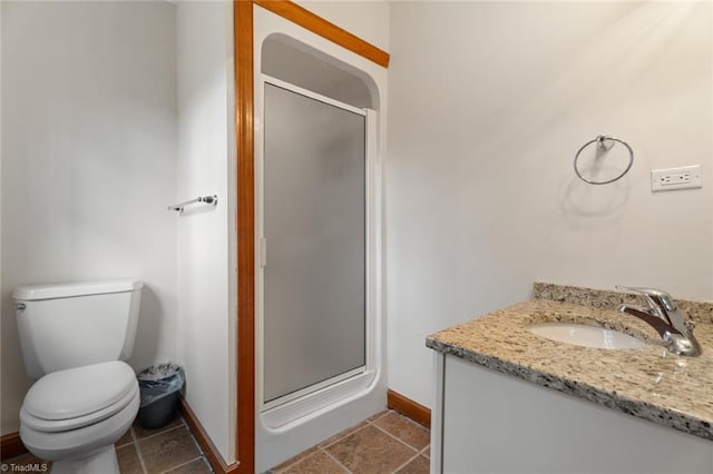 bathroom with toilet, a stall shower, vanity, tile patterned flooring, and baseboards