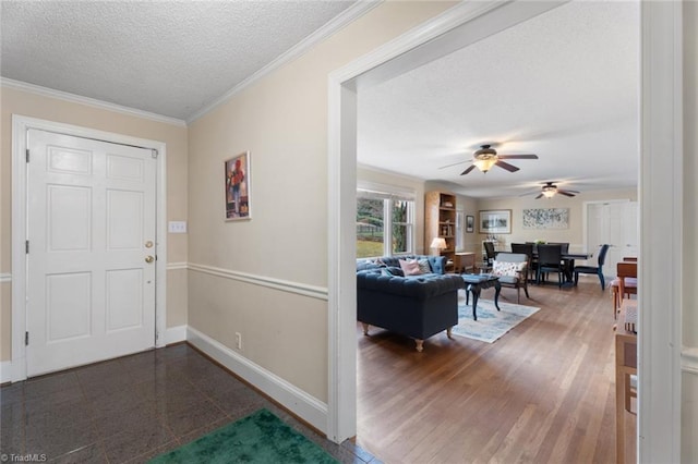 foyer featuring a textured ceiling, dark wood-type flooring, crown molding, and baseboards