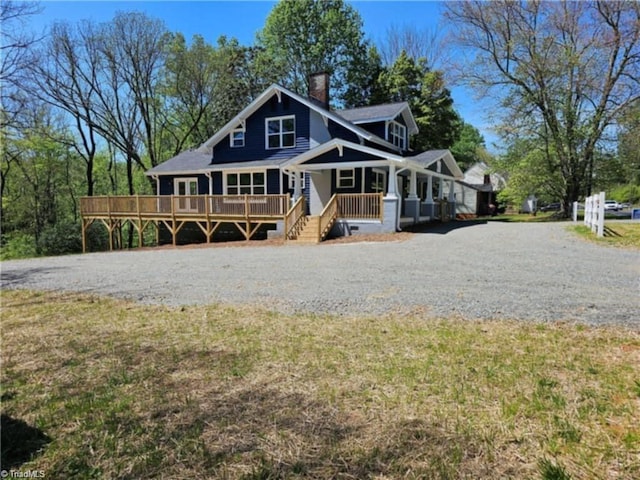 back of property with covered porch and a lawn