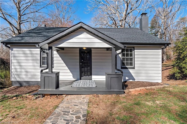 view of front of property with a chimney and roof with shingles